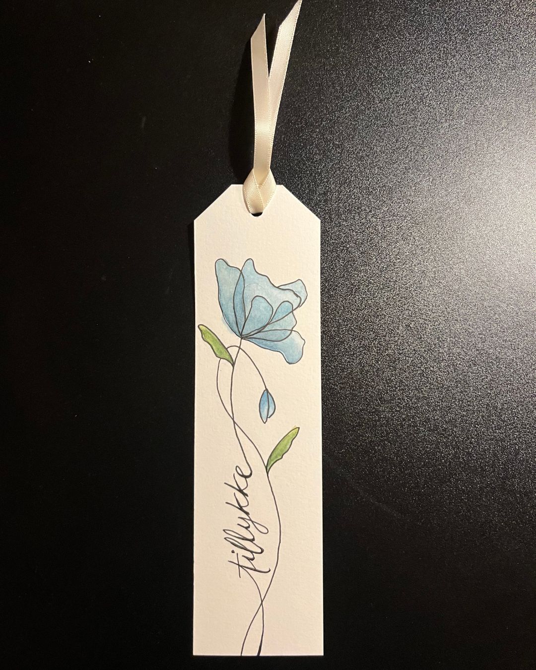 Bogmærke med blå blomst i akvarel